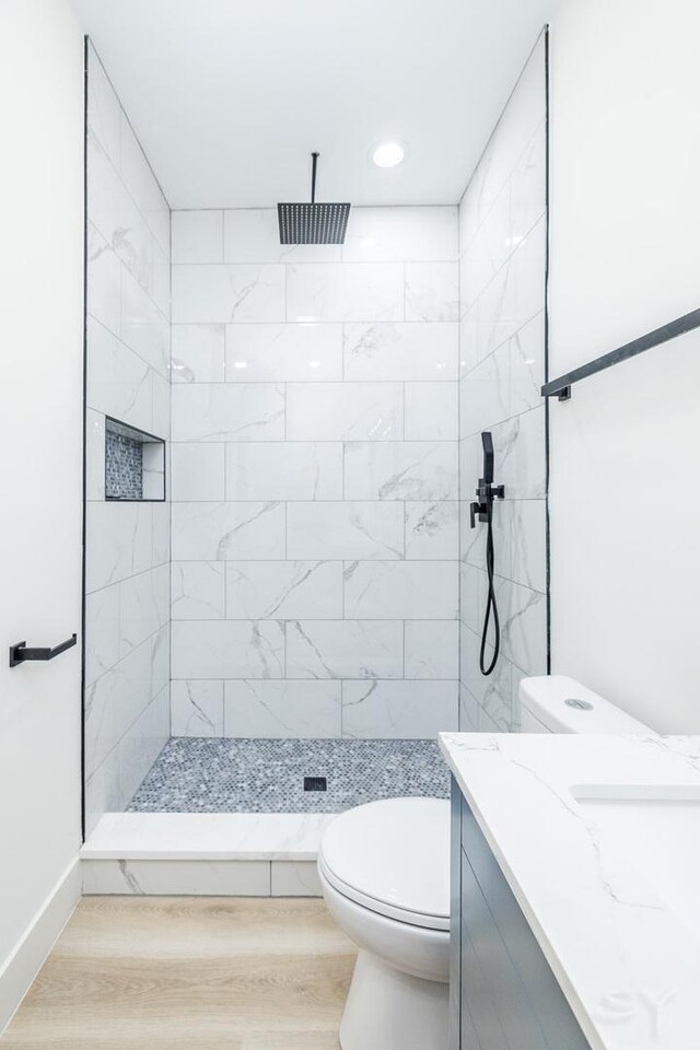 5530 S Michigan Ave, Chicago, IL 60637 - full bathroom featuring vanity, a tile shower, wood finished floors, toilet, and recessed lighting