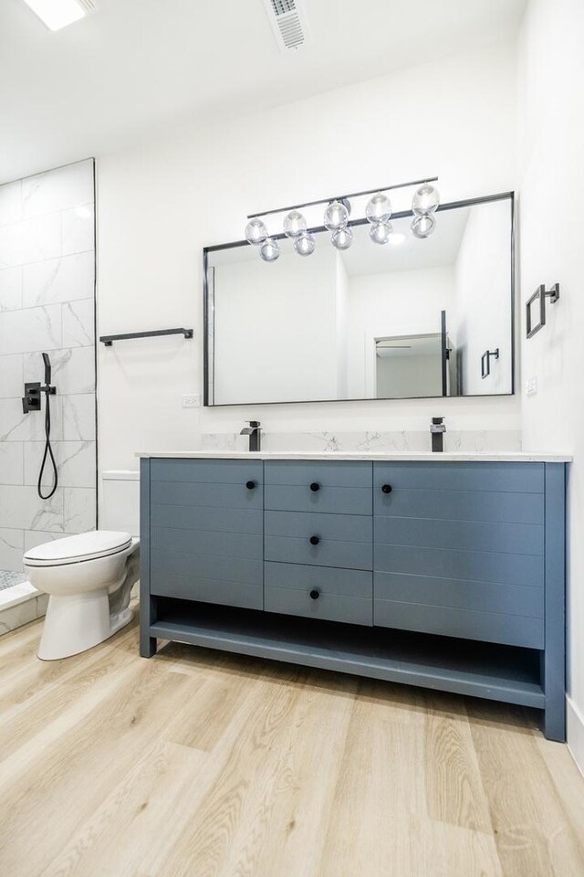 5530 S Michigan Ave, Chicago, IL 60637 - full bathroom with wood finished floors, toilet, double vanity, and tiled shower
