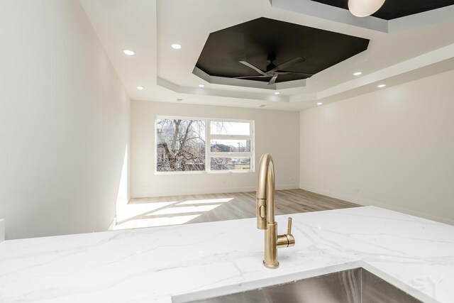 5530 S Michigan Ave, Chicago, IL 60637 - kitchen view of light stone countertops, a sink, wood finished floors, a tray ceiling, and ceiling fan