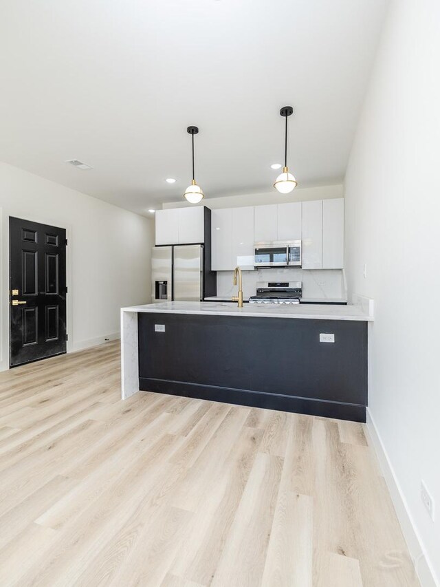 5534 S Michigan Ave, Chicago, IL 60637 - kitchen featuring appliances with stainless steel finishes, a sink, white cabinets, baseboards, and light wood-style flooring