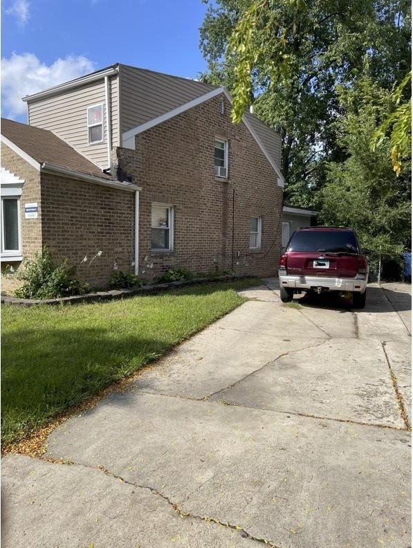 2404 E 97th St, Chicago, IL 60617 - view of side of home with brick siding, concrete driveway, and a lawn