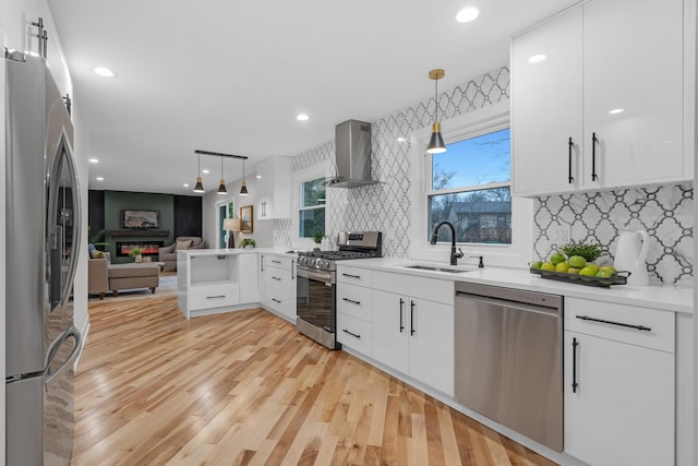274 University Dr, Buffalo Grove, IL 60089 - kitchen with appliances with stainless steel finishes, wall chimney exhaust hood, open floor plan, decorative backsplash, and hanging light fixtures