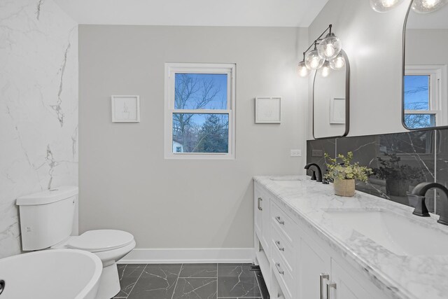 274 University Dr, Buffalo Grove, IL 60089 - full bath with marble look tiles, double vanity, a freestanding tub, toilet, and tasteful backsplash