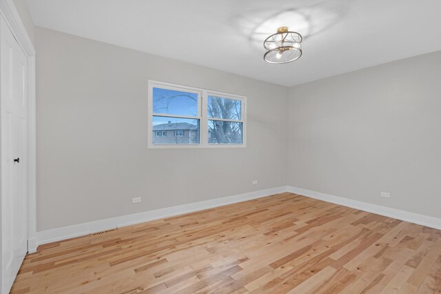 274 University Dr, Buffalo Grove, IL 60089 - empty room featuring light wood-type flooring, a chandelier, and baseboards