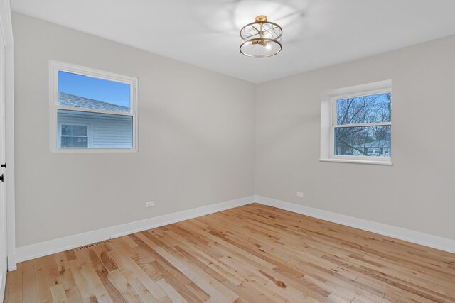 274 University Dr, Buffalo Grove, IL 60089 - empty room featuring light wood-style floors, baseboards, and a chandelier