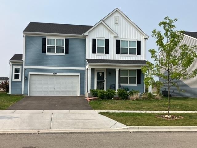 404 Radcliff Ln, South Elgin, IL 60177 - traditional home with a front yard, driveway, a garage, a porch, and board and batten siding