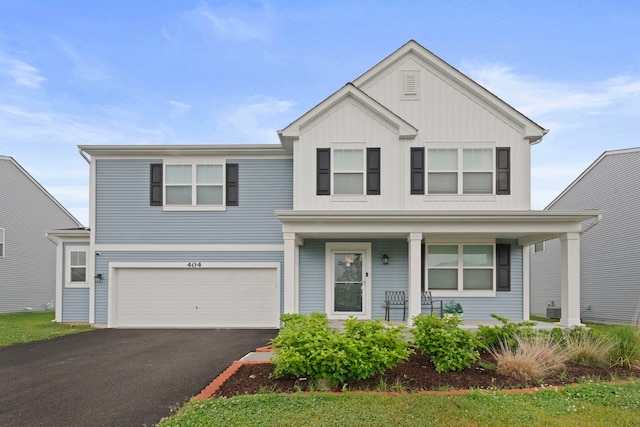 404 Radcliff Ln, South Elgin, IL 60177 - view of front of home featuring a front yard, asphalt driveway, covered porch, a garage, and board and batten siding