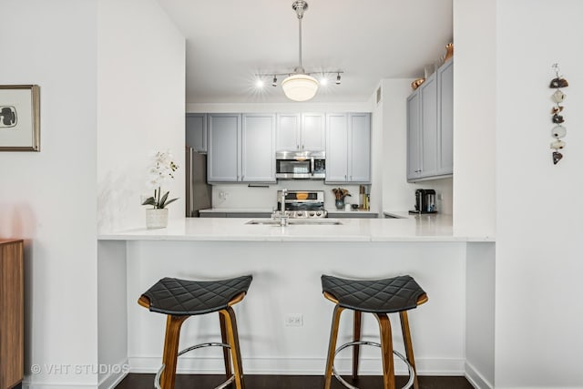 501 N Clinton St Unit 1804, Chicago, IL 60654 - kitchen featuring stainless steel microwave, gray cabinetry, and a peninsula