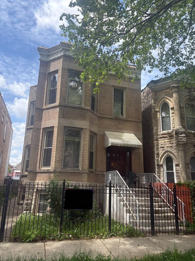 1530 N Springfield Ave, Chicago, IL 60651 - view of front facade with a fenced front yard and brick siding