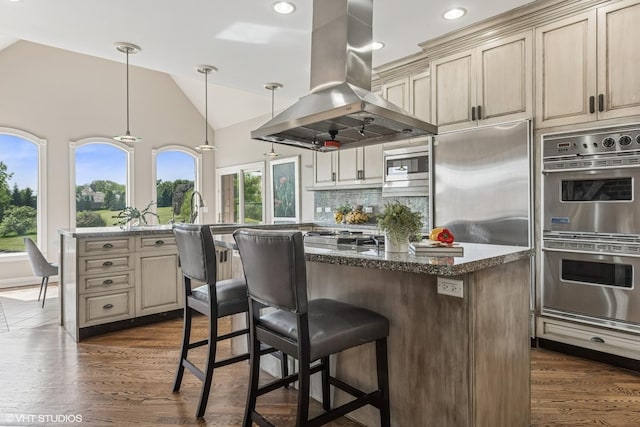 26 Forest Ln, South Barrington, IL 60010 - kitchen featuring range hood, appliances with stainless steel finishes, cream cabinetry, a center island, and a breakfast bar area