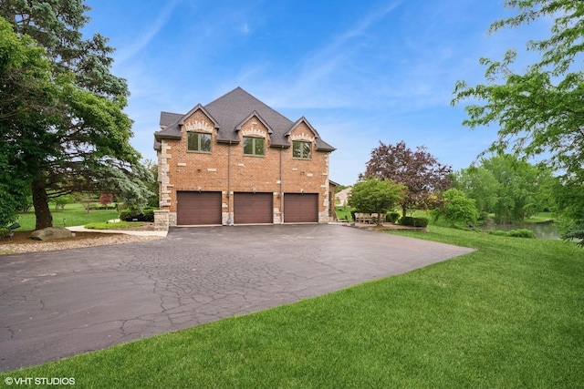 26 Forest Ln, South Barrington, IL 60010 - view of front facade with driveway, stone siding, an attached garage, a front lawn, and brick siding