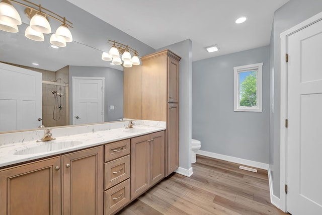 405 S Carol Ln, Braidwood, IL 60408 - bathroom featuring double vanity, toilet, a tile shower, baseboards, and wood finished floors