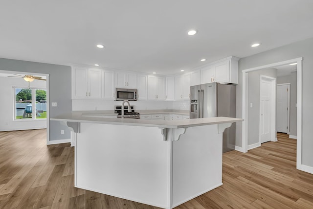 405 S Carol Ln, Braidwood, IL 60408 - kitchen with stainless steel appliances, light countertops, white cabinetry, light wood-type flooring, and recessed lighting