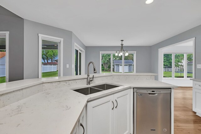 405 S Carol Ln, Braidwood, IL 60408 - kitchen with stainless steel dishwasher, a sink, a chandelier, light wood-style floors, and white cabinets