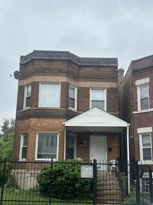 6948 S Eberhart Ave, Chicago, IL 60637 - view of front of house with a fenced front yard, brick siding, and a porch