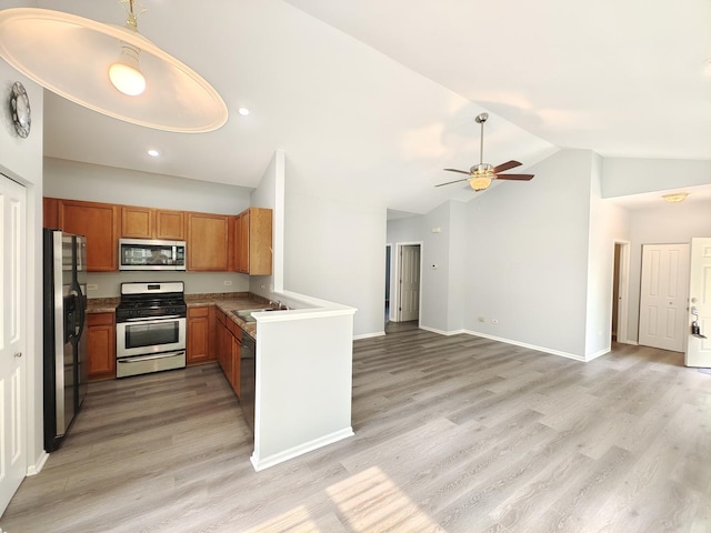 1931 Chase Ln Unit 1931, Aurora, IL 60502 - kitchen featuring stainless steel appliances, vaulted ceiling, brown cabinetry, light wood finished floors, and open floor plan
