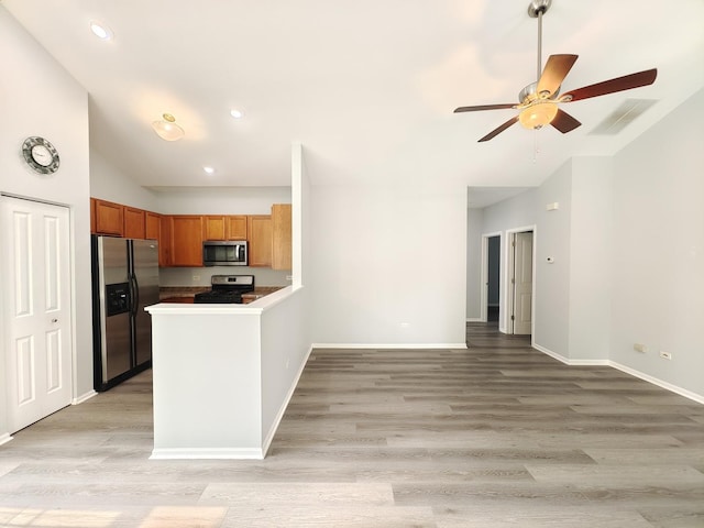1931 Chase Ln Unit 1931, Aurora, IL 60502 - kitchen with stainless steel appliances, lofted ceiling, ceiling fan, brown cabinets, and light wood-type flooring