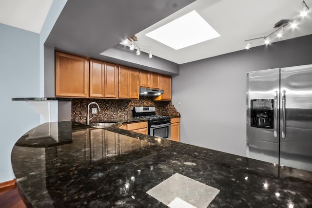 7200 N Ridge Blvd Unit 4H, Chicago, IL 60645 - kitchen with appliances with stainless steel finishes, under cabinet range hood, rail lighting, a skylight, and decorative backsplash