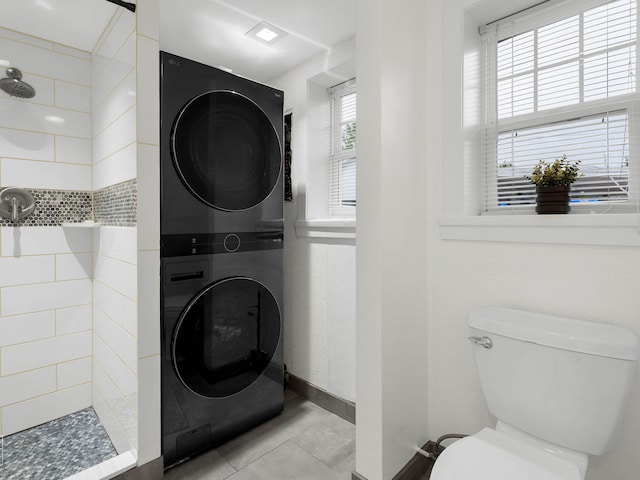 7225 Poplar Ln, Darien, IL 60561 - bathroom with estacked washer and dryer, a tile shower, toilet, tile patterned flooring, and baseboards