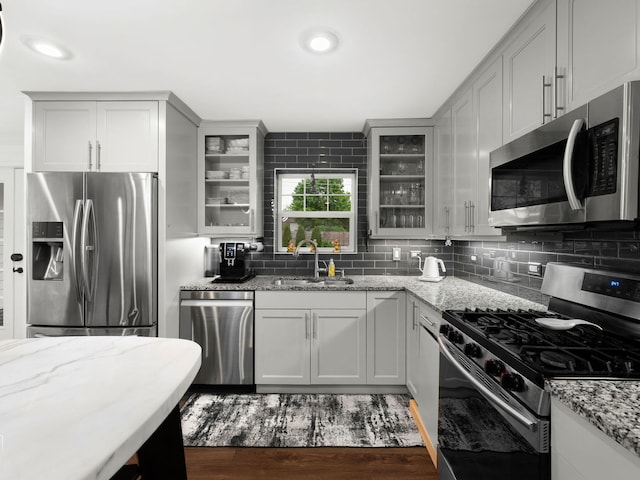 7225 Poplar Ln, Darien, IL 60561 - kitchen featuring stainless steel appliances, a sink, tasteful backsplash, and glass insert cabinets