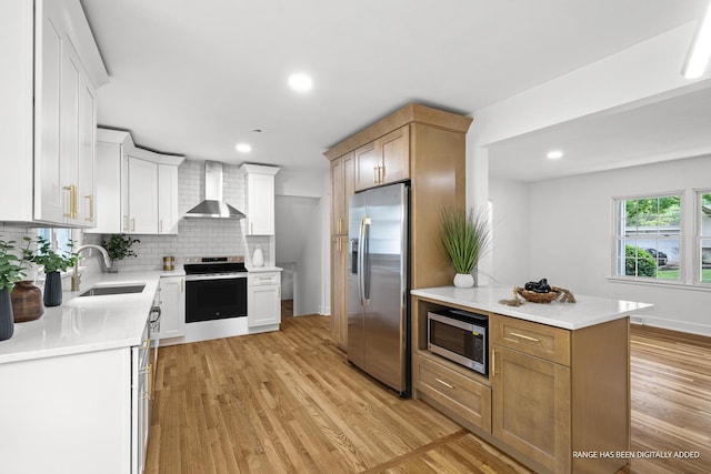 826 Iris Ln, Naperville, IL 60540 - kitchen with appliances with stainless steel finishes, wall chimney range hood, light wood-style floors, tasteful backsplash, and light countertops