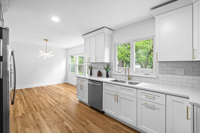 826 Iris Ln, Naperville, IL 60540 - kitchen with stainless steel dishwasher, light countertops, backsplash, light wood-style floors, and white cabinetry