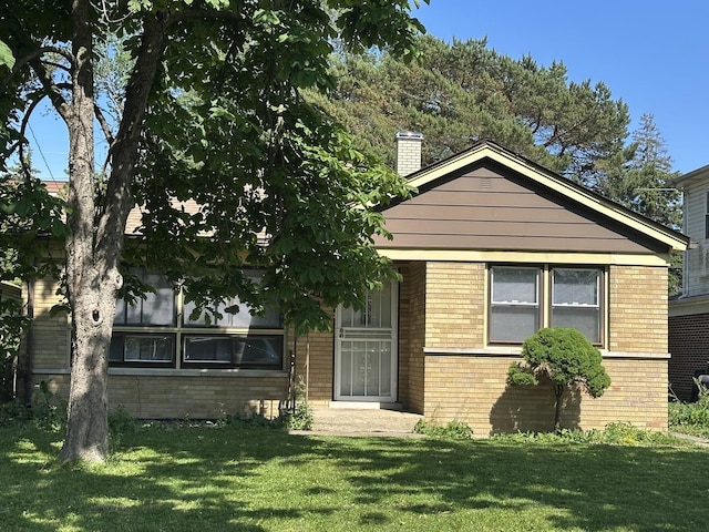 14631 Michigan Ave, Dolton, IL 60419 - view of front facade featuring brick siding, a front yard, and a chimney