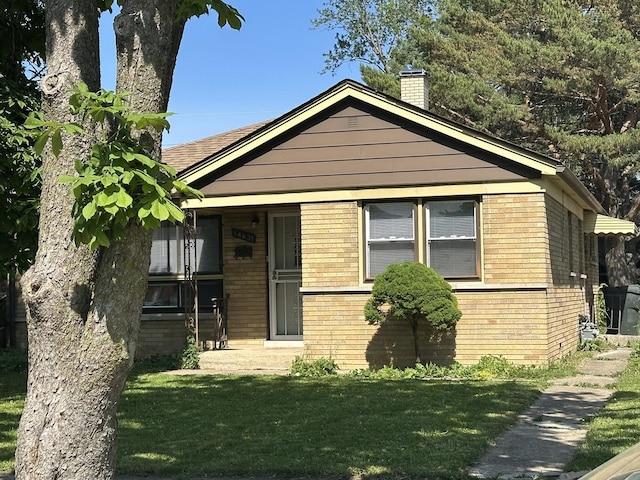 14631 Michigan Ave, Dolton, IL 60419 - bungalow-style home with brick siding, a chimney, and a front yard