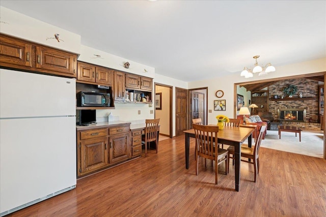 10 S Canterbury Rd, Aurora, IL 60506 - dining room featuring wood finished floors, a chandelier, and a brick fireplace