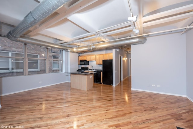 500 S Clinton St Unit 604, Chicago, IL 60607 - kitchen with light brown cabinetry, black appliances, light wood-style flooring, and open floor plan