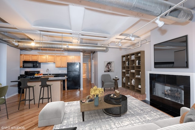 500 S Clinton St Unit 604, Chicago, IL 60607 - living area featuring light wood-type flooring, baseboards, and a tiled fireplace