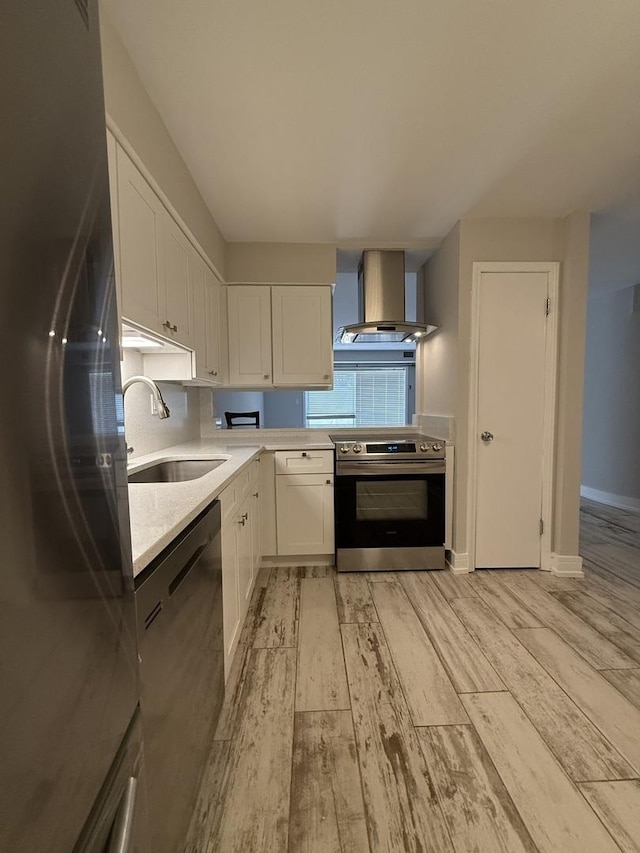 4508 Beau Monde Dr Unit 5, Lisle, IL 60532 - kitchen with appliances with stainless steel finishes, wall chimney exhaust hood, white cabinets, light countertops, and light wood-style floors