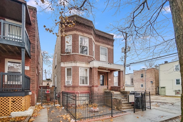 5514 S Winchester Ave, Chicago, IL 60636 - view of front facade with brick siding, a fenced front yard, a gate, cooling unit, and a balcony