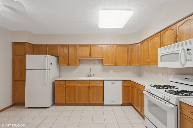 650 S River Rd Unit 405, Des Plaines, IL 60016 - kitchen with white appliances, a sink, light countertops, and tasteful backsplash