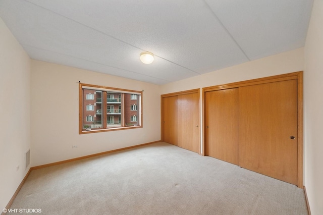650 S River Rd Unit 405, Des Plaines, IL 60016 - unfurnished bedroom with carpet flooring, multiple closets, and baseboards