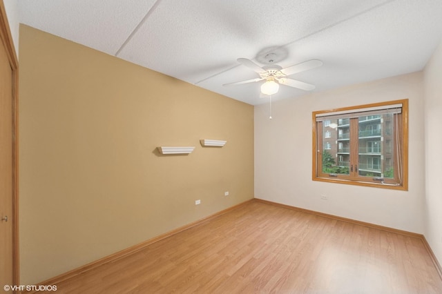 650 S River Rd Unit 405, Des Plaines, IL 60016 - empty room with light wood-style floors, a ceiling fan, baseboards, and a textured ceiling
