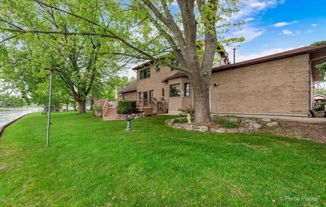 25827 W Andrew Ct, Ingleside, IL 60041 - view of front facade with brick siding, a front yard, and a deck with water view