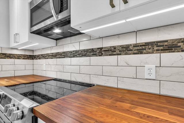 1910 Melrose Dr Unit C, Champaign, IL 61820 - kitchen featuring butcher block counters, stainless steel appliances, tasteful backsplash, and white cabinetry