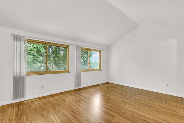 1910 Melrose Dr Unit C, Champaign, IL 61820 - spare room featuring vaulted ceiling, light wood-style floors, and baseboards