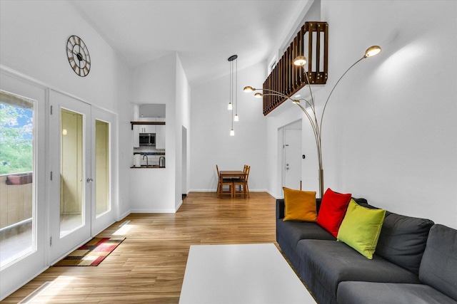 1910 Melrose Dr Unit C, Champaign, IL 61820 - living room featuring high vaulted ceiling, light wood-style flooring, french doors, and baseboards