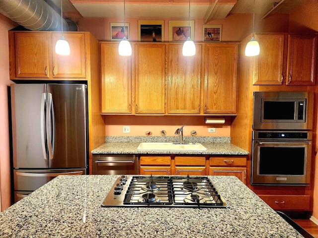 1530 S State St Unit 17R, Chicago, IL 60605 - kitchen featuring appliances with stainless steel finishes, a sink, light stone countertops, pendant lighting, and brown cabinetry