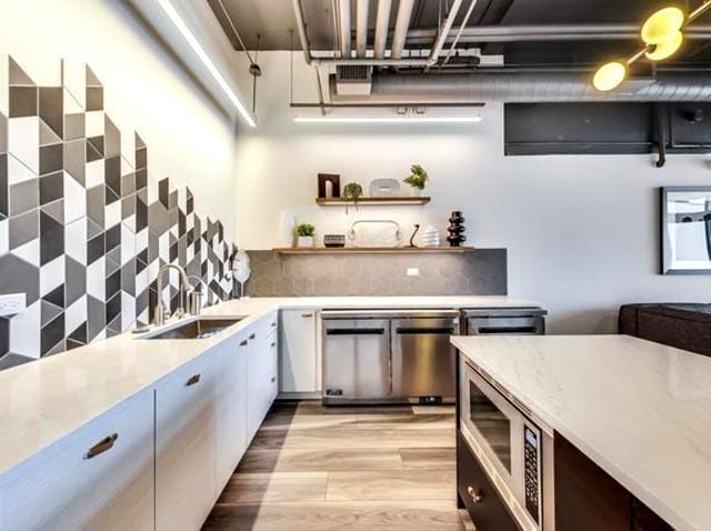 1530 S State St Unit 17R, Chicago, IL 60605 - kitchen featuring appliances with stainless steel finishes, a sink, tasteful backsplash, light wood finished floors, and open shelves