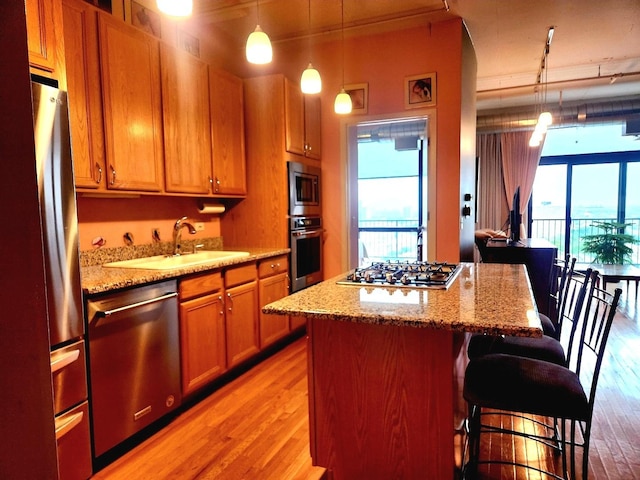 1530 S State St Unit 17R, Chicago, IL 60605 - kitchen featuring appliances with stainless steel finishes, a sink, light wood finished floors, and a kitchen bar