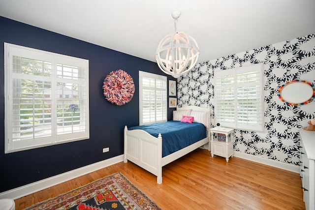 714 Turner Ave, Glen Ellyn, IL 60137 - bedroom with wallpapered walls, a chandelier, multiple windows, and light wood-style floors