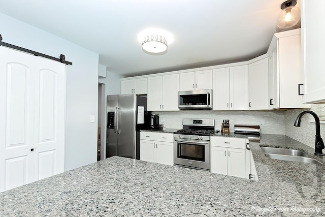 1381 Regency Ln, Lake Villa, IL 60046 - kitchen with appliances with stainless steel finishes, a sink, stone counters, decorative backsplash, and a barn door