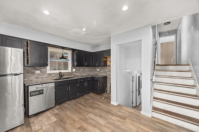 505 E 146th St, Dolton, IL 60419 - kitchen featuring appliances with stainless steel finishes, stone counters, backsplash, light wood-style flooring, and dark cabinetry