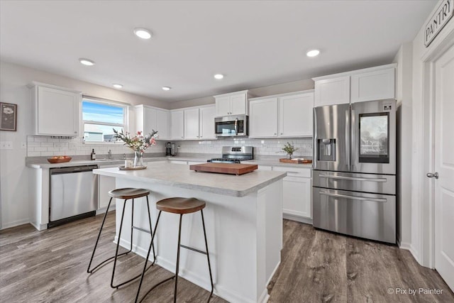 1715 Bayberry Ln, Pingree Grove, IL 60140 - kitchen with appliances with stainless steel finishes, white cabinetry, light countertops, decorative backsplash, and a kitchen island