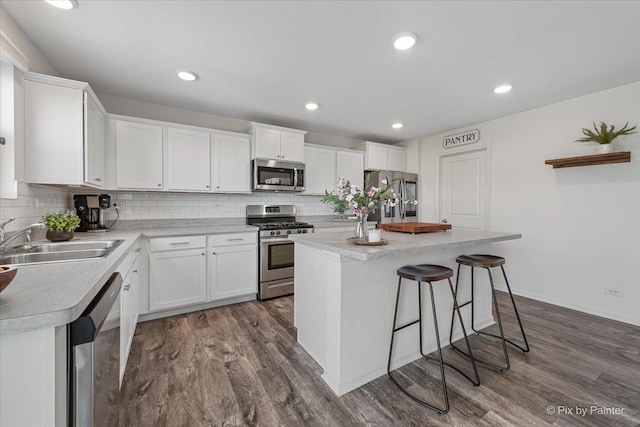 1715 Bayberry Ln, Pingree Grove, IL 60140 - kitchen with stainless steel appliances, a sink, dark wood-style flooring, white cabinetry, and decorative backsplash