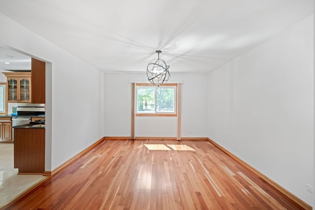 720 Dunhill Dr, Buffalo Grove, IL 60089 - unfurnished dining area with light wood-style floors and a chandelier