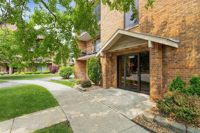 16807 81st Ave Unit 2S, Tinley Park, IL 60477 - doorway to property featuring brick siding and a lawn